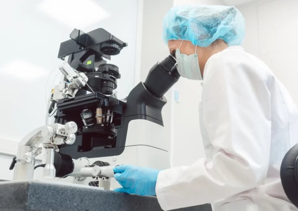 Woman doctor working in medical lab with manipulator and microscope